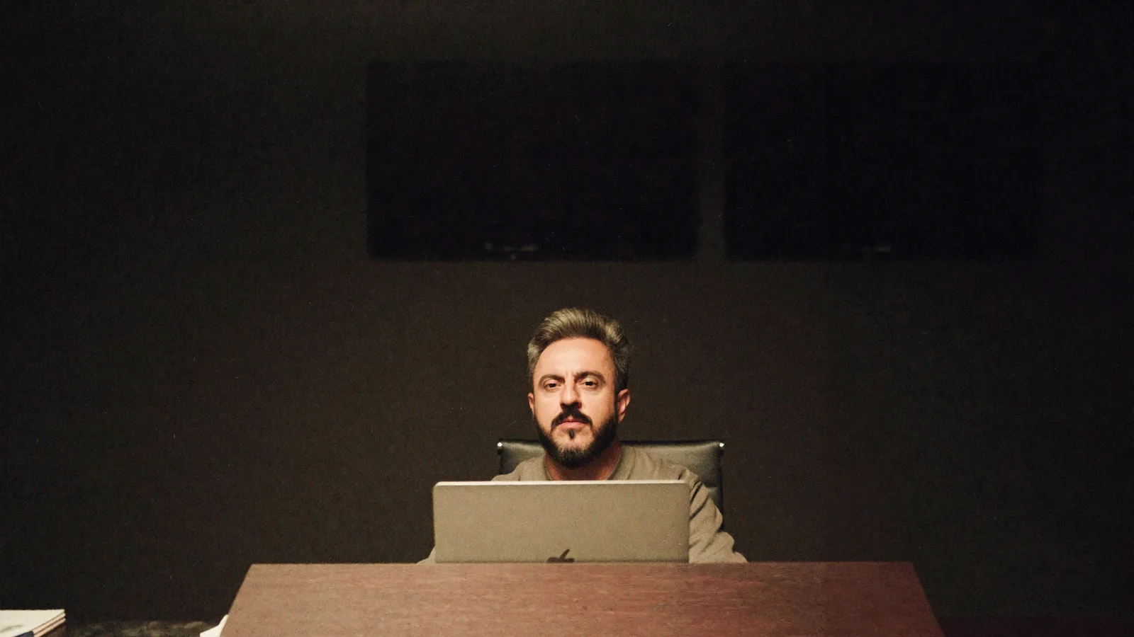 William Motta sentado à mesa em ambiente de trabalho com iluminação quente, laptop visto por trás, ilustrando a medição de share of voice da marca em respostas de IA